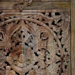 detal rzezbionej mandali i okragle uchwyty meble orientalne witryna drewniana