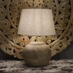włączona lampa stołowa rustykalna ciepłe nastrojowe światło w sypialni drewno mango
