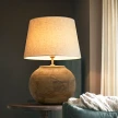 duża lampa drewniana rustykalna 30cm kula z drewna mango włączona w przytulnym salonie na stoliku