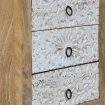 zbliżenie na ręczne rzeźbienia szuflad motyw roślinny przecierana biała farba shabby chic drewno mango