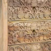 zbliżenie na misterny roślinny relief na frontach szuflad lakierowane drewno mango i metalowe mosiężne uchwyty kołatki