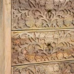 zbliżenie na misterny roślinny relief na frontach szuflad lakierowane drewno mango i metalowe mosiężne uchwyty kołatki