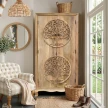 meble indyjskie szafa drewniana natural tree 180 cm z rzeźbionym drzewem życia w jasnym salonie boho przy oknie