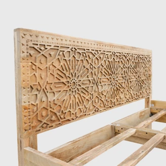 zbliżenie na ręcznie rzeźbione geometryczne mozaiki i orientalne wzory na zagłówku łóżka z litego mango kolekcja boho loco
