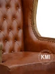 zbliżenie na głębokie pikowanie i mosiężne nity na drewnianej ramie fotela windsor
