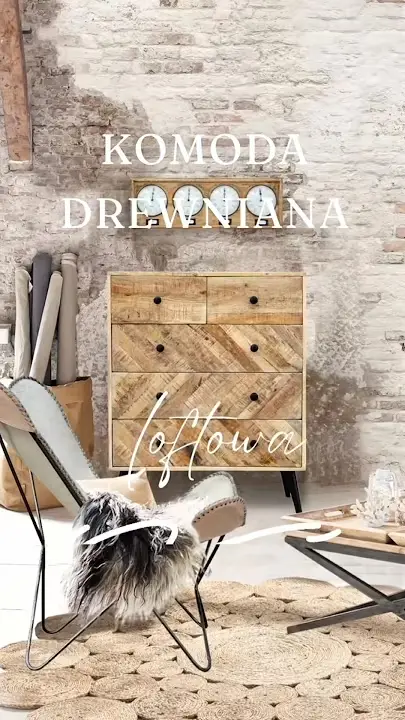 Prezentacja wideo: Drewniana komoda w stylu industrialnym (model Riverside) z pięcioma szufladami o ukośnym układzie drewna i czarnymi detalami, osadzona na ukośnych nóżkach, ustawiona na tle surowej, bielonej ściany z cegły obok fotela typu motyl i okrągłego, plecionego dywanu z juty – Meble Loftowe