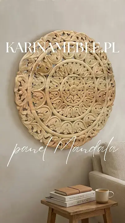 Prezentacja wideo: Okrągły, drewniany panel ścienny z jasnego drewna mango (model Mandala) z bogato rzeźbionym, roślinnym motywem rozety, zawieszony na jasnej ścianie nad małym drewnianym stolikiem z książkami i kubkiem, obok fragmentu jasnej sofy – Meble Indyjskie