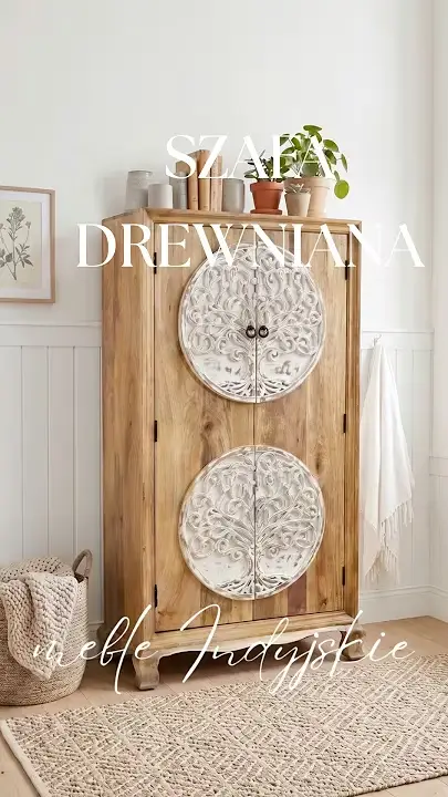Prezentacja wideo: Wysoka dwudrzwiowa szafa orientalna o szerokości 90 cm (model White Tree) wykonana z litego, naturalnego drewna mango z dwoma dużymi, okrągłymi elementami ozdobionymi kunsztownie rzeźbionym motywem drzewa w kolorze przecieranej bieli, wyposażona w ozdobne gięte nóżki oraz małe metalowe uchwyty, udekorowana na blacie książkami i roślinami w glinianych doniczkach, zaprezentowana w jasnym, przytulnym pokoju na tle białej boazerii, stojąca na podłodze obok plecionego kosza z kocem i strukturalnego dywanu – Meble Indyjskie / Orientalne